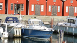 Nimbus 250 R förtöjd framför små röda hus